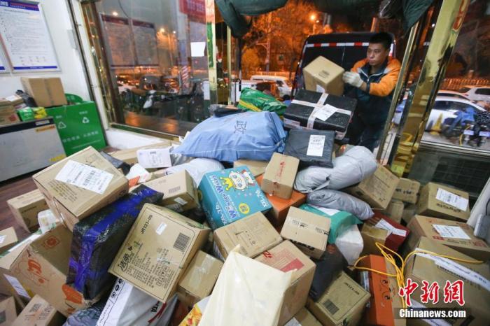 资料图：11月13日，山西太原的物流业工作人员加紧给快递卸车。/p中新社记者 张云 摄