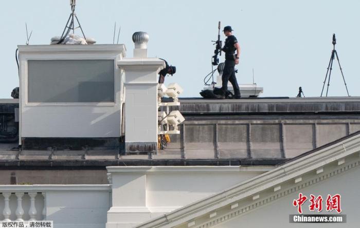 当地时间5月30日，美国华盛顿，美国特情局反狙击队的一名队员行走在白宫的房顶上。
