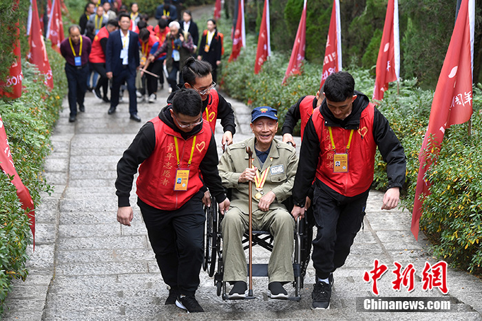 图为青年志愿者护送抗战老兵。 /p中新社记者 俞靖 摄