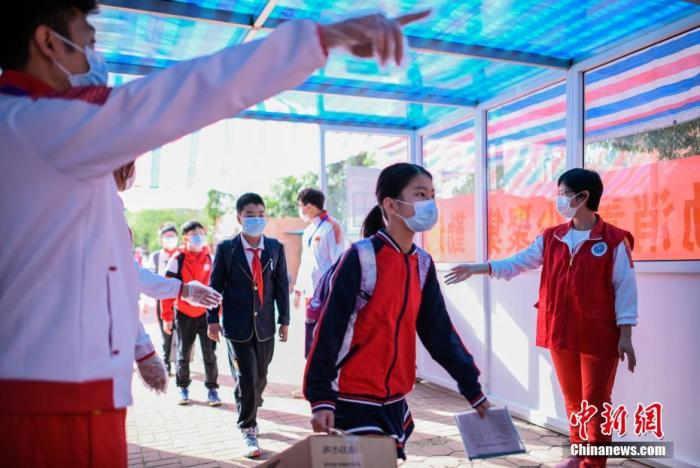 资料图：小学生通过体温检测通道进入校园。/p中新社记者 佟郁 摄